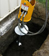 Installing a helical pier during a foundation repair in Tonawanda