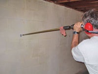 Drilling the hole in the foundation wall for street creep repairs in Derby