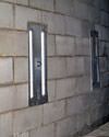 an inside view of foundation wall anchors installed along a basement wall to brace and repair the structure in Angola
