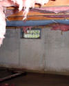 Western New York crawl space with vents, showing mold, rot, and fiberglass insulation dripping off the ceiling.