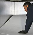 A contractor installing TerraBlock™ floor insulation in a Orchard Park crawl space