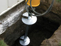 Installing a helical pier system in the earth around a foundation in Lockport