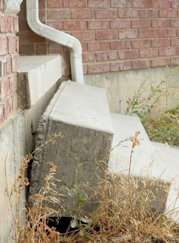 sinking outdoor concrete steps showing cracking and soil washout in Akron