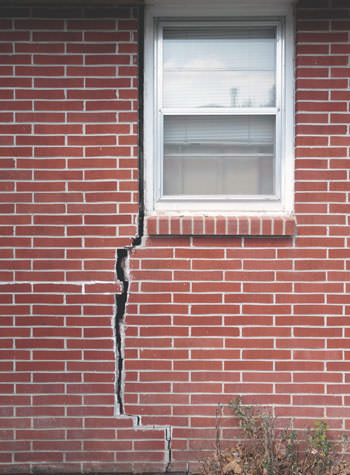severe foundation wall cracks along a window in Attica