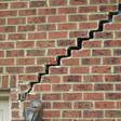 stair step cracking reaching from a window along the foundation wall in Rochester