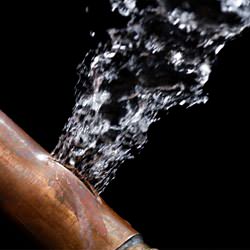 A bursting copper pipe in Lockport, with water gushing out.