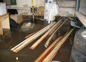 A severely flooding basement in Orchard Park, with lumber and personal items floating in a foot of water