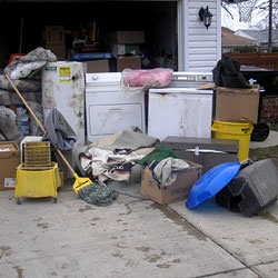 Soaked, wet personal items sitting in a driveway, including a washer and dryer in Hamburg.